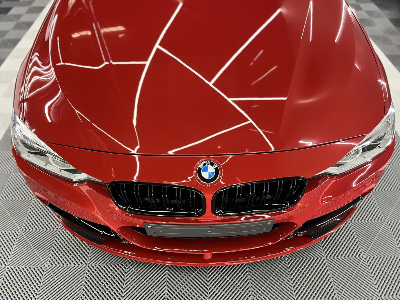 Capó de un BMW rojo con la lámina de protección recién aplicada en el taller de Marbella Custom Cars